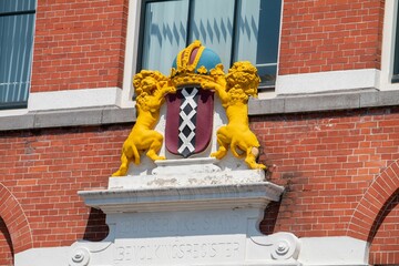 Coat of arms of Amsterdam on the facade of a brick building