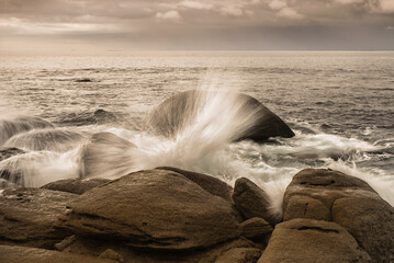 Landscape France Brittany rocky coast with raging Atlantic Ocean and waves that create fontaines in...
