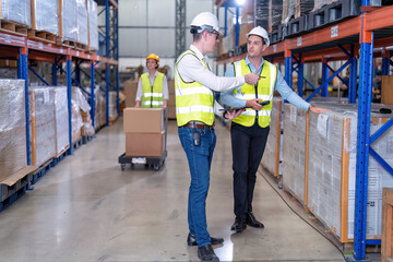 Worker in warehouse hold tablet check list perform inventory stock check goods boxes on the storage...