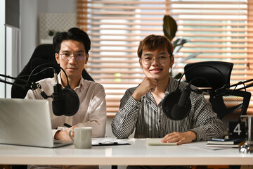 Two Asian male announcers Hosting a radio program, talks, interviews, announcements, advertisements.