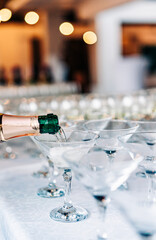 waiter pouring champagne wine from bottle in glasses