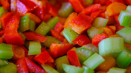 Freshly cut raw vegetables on a wooden board. Celery and paprika. Prepared for cooking.