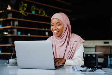 Young muslim woman wearing headscarf working on laptop in office - 539488512