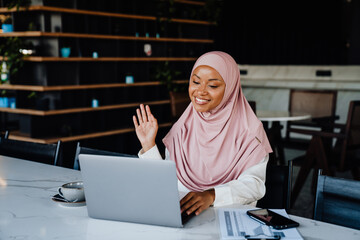Young muslim woman wearing headscarf working on laptop in office