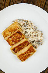 delicious pancakes with fried mushrooms on a plate.
