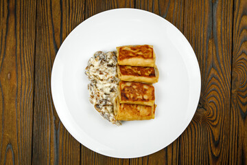 delicious pancakes with fried mushrooms on a plate.
