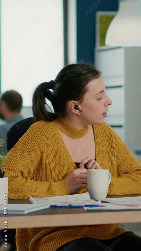 Poster Startup office employee using laptop in video conference with clients and manager talking about marketing strategy. Casual business woman in group call discussing with remote coworkers about charts.