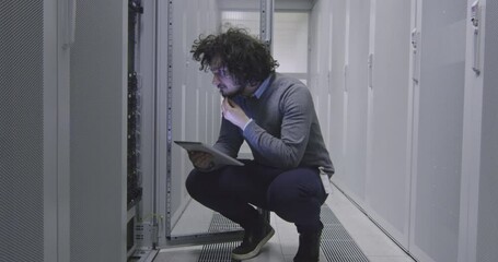IT engineer or data science specialist working on tablet computer in server room at a modern cloud computing virtual data center supercomputer. - Powered by Adobe