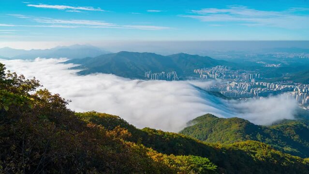 Beautiful nature between downtown city and mist fogy  flows around the mountains  in the morning in autumn at Cheonmasan mountain in Namyangju-si, Gyeonggi-do, South Korea.