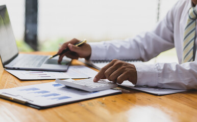 Businessman or accountant working Financial investment on calculator, calculate, analyze business and marketing growth on financial document data graph, Accounting, Economic, commercial concept.