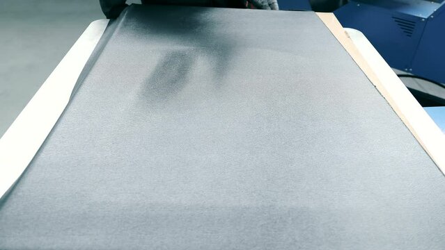 Production of rubber car mats. The press, using the method of vacuum compression, forms the shape of a rug made of rice paper