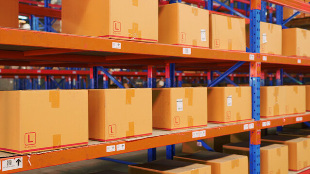 A large warehouse has cargo cardboard boxes on shelves prepared for shipping by logistics transportation. A lot of boxes are ready for distribution or moving into containers and sending to customers.