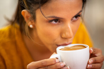 Close up young woman drinking hot cup of coffee