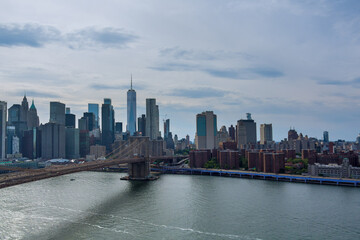 Fototapeta na wymiar An aerial view of Manhattan along East River over picturesque Brooklyn Bridge in New York City, United States.