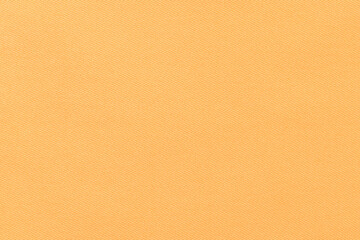 Texture of natural orange color twill fabric close-up. the background for your mockup