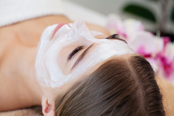 Fototapeta premium Attractive funny woman with a clay mask on her face.
