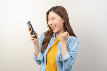 Happy Asian woman holding a smartphone and winning the prize.