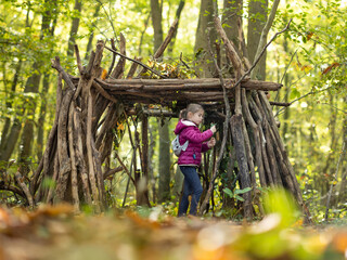 une petite fille et sa cabane en bois en forêt - 539501182