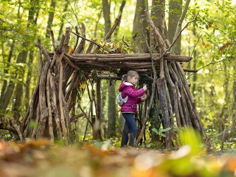 une petite fille et sa cabane en bois en for&ecirc;t
