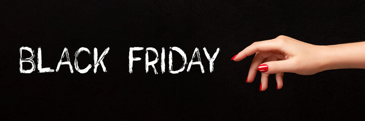 Black Friday sign on black background with female hand with red nails banner. Wide panoramic header. Shopping concept