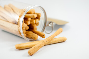 Delicious seaweed breadsticks packed in a clear plastic can and laid on a white background.