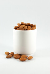 Tasty almond in a white cup isolated on white background, close up.