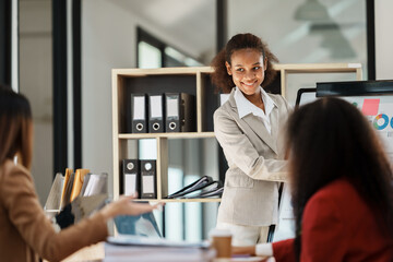 African businesswoman giving presentation on flip chart discussing new marketing research results with executive team in boardroom, black employee reporting about project at meeting