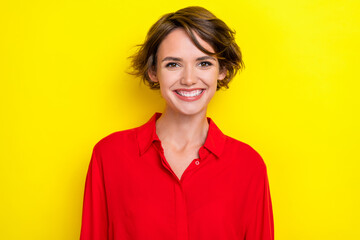 Photo of nice cute satisfied pleasant woman with bob hairstyle dressed red shirt toothy smiling isolated on yellow color background