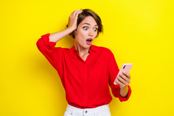 Portrait of nice cute impressed girl with bob hairdo dressed red shirt hand on head staring read news isolated on yellow color background