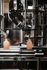 Fototapeta na wymiar Industrial wine bottling plant theme. Modern industry production line for alcohol drink bottling and packaging.