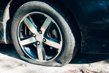 Close up of a car flat tire, air tire pressure lose on the road.
