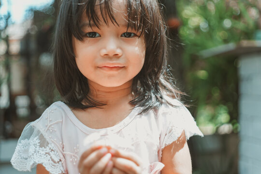 Cute Little Asian Girl Holding A White Bouquet. Child Planting Spring Flowers. 