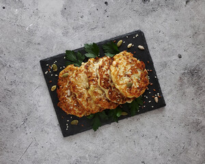 Zucchini fritters on light background, top view. 