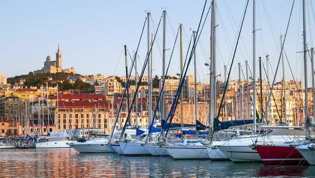 Timelapse of moving boats and yachts - water and light reflections in the evening port of Marseille
