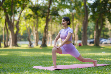 Yoga in the park. Young Asian woman practicing yoga pose at the park.