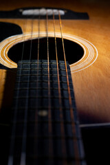 Close-up and details of old acoustic guitar, Line and curve of instrument, Selective focus of guitar strings with fretboard and neck, Musical concept, Guitar background