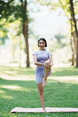 Beautiful young asian woman yoga exercising in the park.