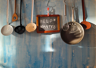 Help wanted sign,restaurant or cafe looking for staff after corona lockdown, kitchen utesnils and message on blackboard