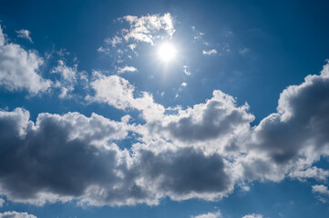 Naklejka na ściany i meble Cumulus clouds against the blue sky on a summer day.