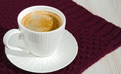 Cup of coffee on a burgundy winter background.