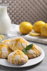 Plate with delicious lemon cookies and mint on grey table