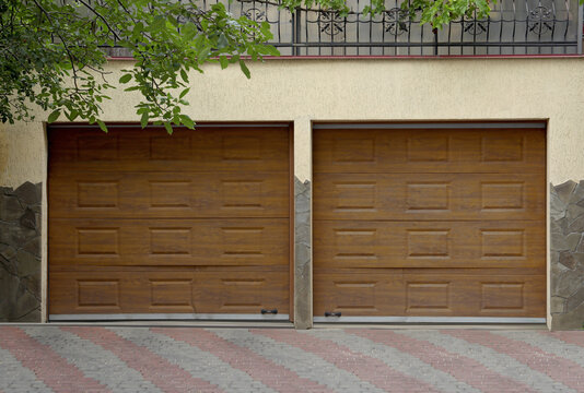 Building With Brown Sectional Garage Doors And Paved Driveway