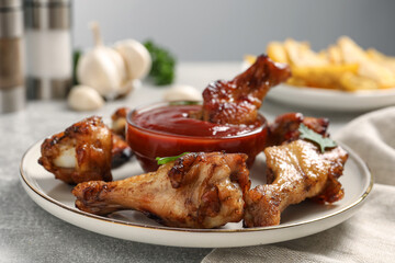 Delicious fried chicken wings served with sauce on light table