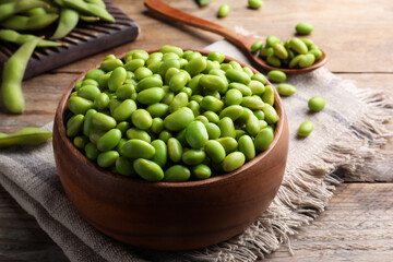 Bowl of delicious edamame beans on wooden table