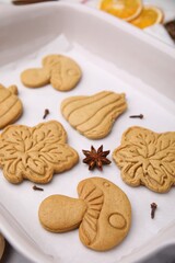 Different tasty cookies and spices on white parchment