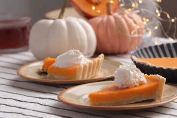 Fresh homemade pumpkin pie with whipped cream on table