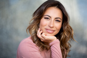 Naklejka premium Close up beautiful young woman smiling with hand to face