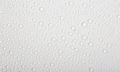 Water drops on glass as a background. Condensation on a cold drink. White background with drops texture.