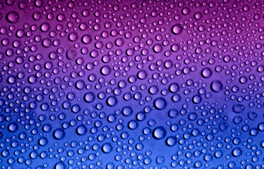 Fototapeta na wymiar Water drops on glass as a background. Condensation on a cold drink. Multicolored background with drops texture.