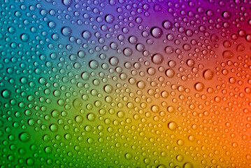 Water drops on glass as a background. Condensation on a cold drink. Multicolored background with drops texture.